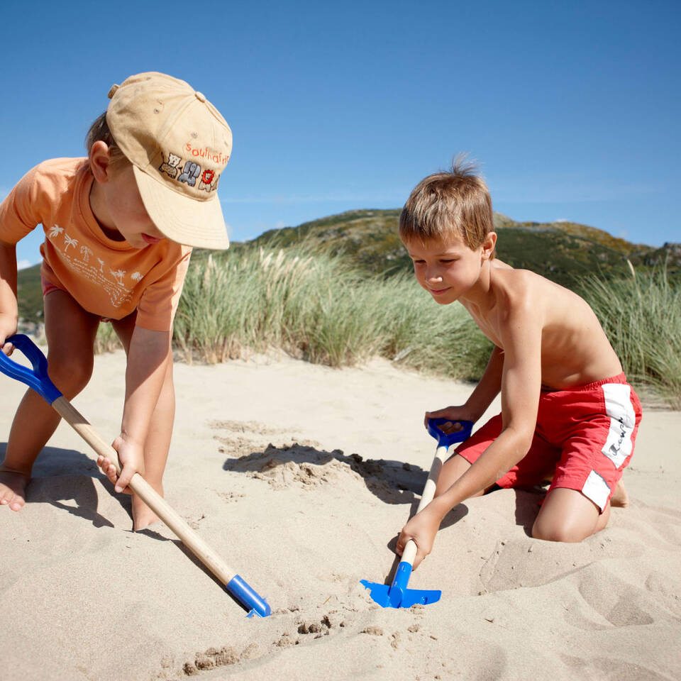 Local Area Children digging a hole on a beach