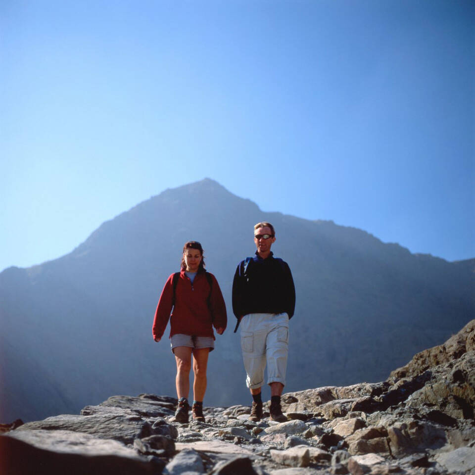 Local Area Couple walking together Mount Snowdon on the Pyg Track in Snowdonia National Park North Wales Large